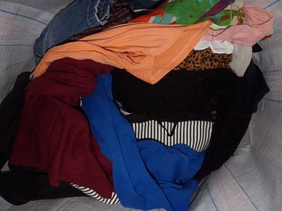 a pile of clothes that is sitting on a bed