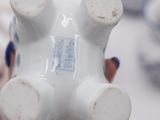 a person holding a white vase in their hand