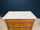 an old wooden dresser with marble top in a room
