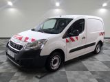la camionnette blanche est garée sur un sol carrelé en damier