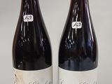 two bottles of wine sitting next to each other on a table