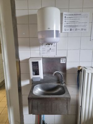 une salle de bains avec un lavabo et un miroir au mur