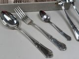 four spoons, two forks, and a knife on a table