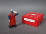 figurine of a man in a red cape standing next to a red box