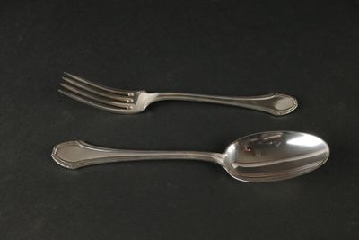 deux cuillères et une fourchette posées sur une table noire