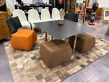 une table et des chaises dans une pièce avec un tapis au sol