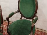 pair of green velveted chairs with carved arms and arms