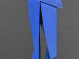 une sculpture en papier bleu représentant une femme debout sur un socle