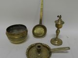 several antique brass objects including a candle, spoon, and measuring spoon
