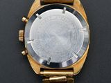 a close up of a watch on a black surface with a black background