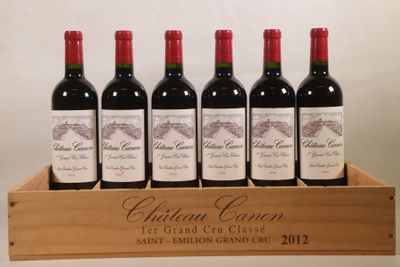 six bouteilles de vin rouge dans une caisse en bois sur une table
