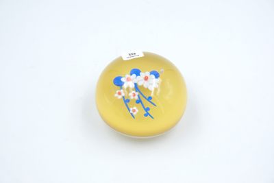 a small yellow object with blue and white flowers on it