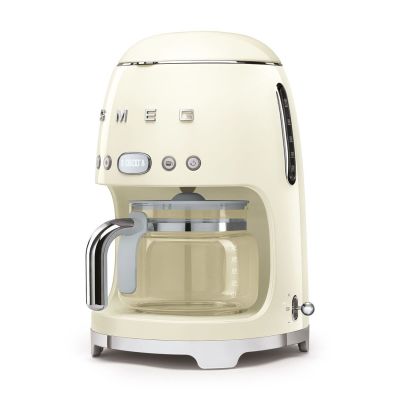une cafetière à crème sur fond blanc, posée sur une surface blanche