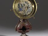 une horloge posée sur un socle orné d'une image