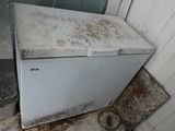 a dirty refrigerator in the corner of a dirty room