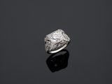 une bague en diamant et en or blanc sur un fond noir