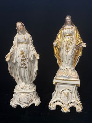 une paire de statues blanches et dorées représentant la Vierge Marie et Jésus
