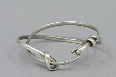 bracelet en argent orné d'un nœud sur fond gris