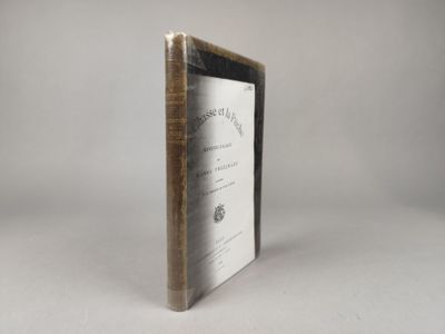 un vieux livre posé sur une table à côté d'un mur blanc