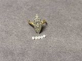 un gros plan d'une bague en or sertie de diamants sur une surface grise