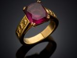 a gold ring with a ruby stone in the center