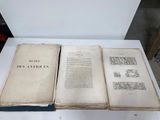 an old book sitting on top of a white table next to another book