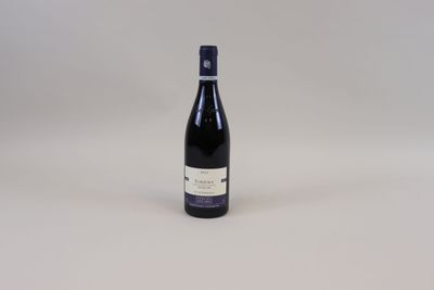 une bouteille de vin posée sur une table blanche