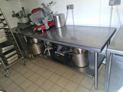 une cuisine avec une table sur laquelle sont posés de nombreux ustensiles de cuisine
