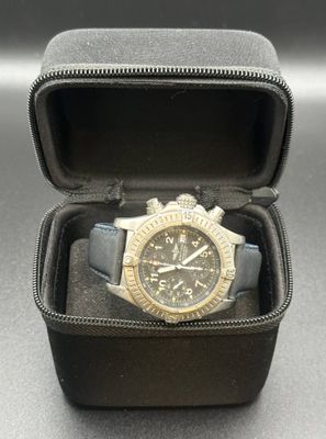 a watch in a black case on a table