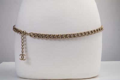 Collier ras-du-cou en chaîne dorée orné d'un pendentif en forme de croix, présenté sur un socle en forme de mannequin