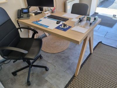 un bureau avec un ordinateur et une chaise devant