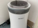 a white air purifier sitting on the floor next to a wall