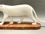 a figurine of a white cat on a wooden base
