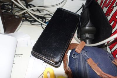 un téléphone portable posé sur un sac, à côté d'un ordinateur portable
