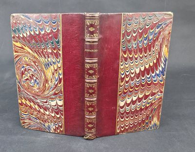 un vieux livre à la couverture rouge ornée de motifs dorés et bleus