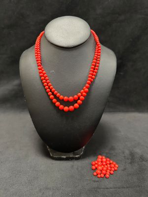 a red beaded necklace and matching earrings on a mannequin