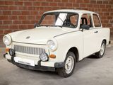 a small white car that is parked in front of a brick wall