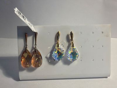 three pairs of earrings on display on a white surface