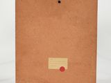 a brown notebook with a red dot on the cover