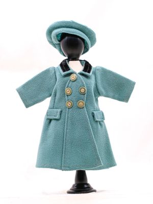 un mannequin vêtu d'un manteau bleu et d'un chapeau