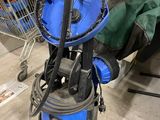 un aspirateur bleu et noir et un caddie à l'arrière-plan