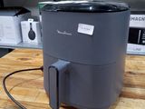 une petite friteuse à air chaud posée sur une table dans une cuisine