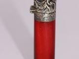 une bouteille en verre rouge ornée d'un dragon argenté