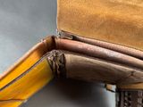 a close up of a brown shoe with a yellow shoelace