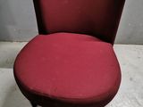 a red chair sitting on top of a white floor next to a wall