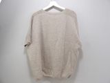 sweater hanging on a hanger on a white wall in a room