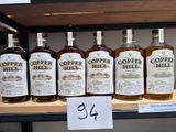 several bottles of copper hill whiskey on a shelf in a store