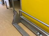 un cariste assis par terre près d'un mur jaune