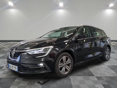 La voiture noire est garée sur un sol en dalles à damier.