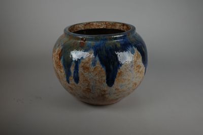 un vase bleu et marron posé sur une table